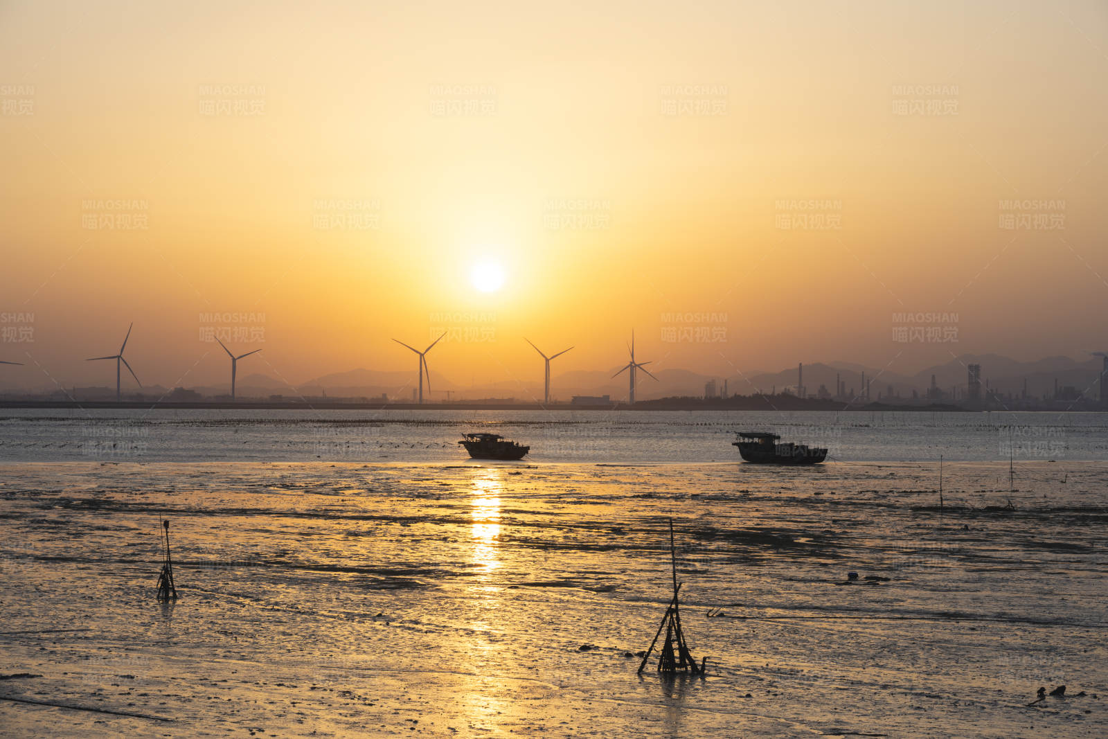 夕阳下的海上风车与渔船