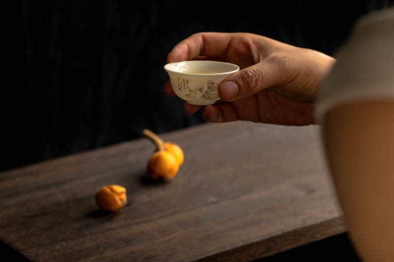手握茶杯 桌上果子