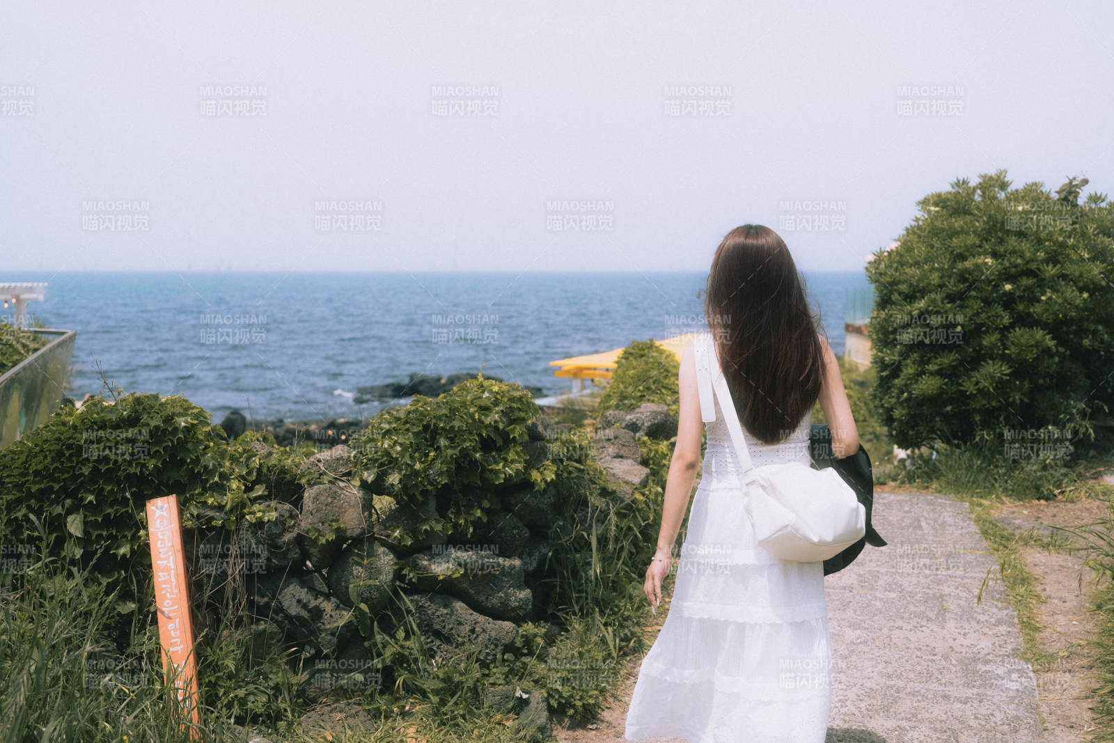 海邊漫步的白衣女子