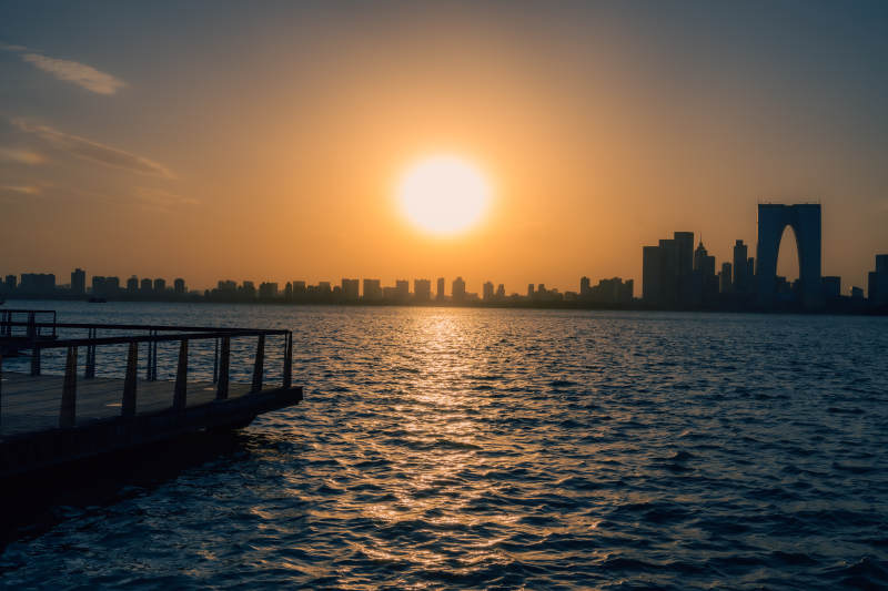湖畔夕阳映城市剪影