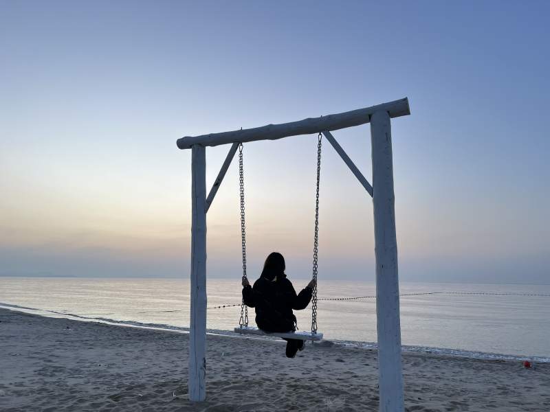 海邊日落 一人獨蕩秋千