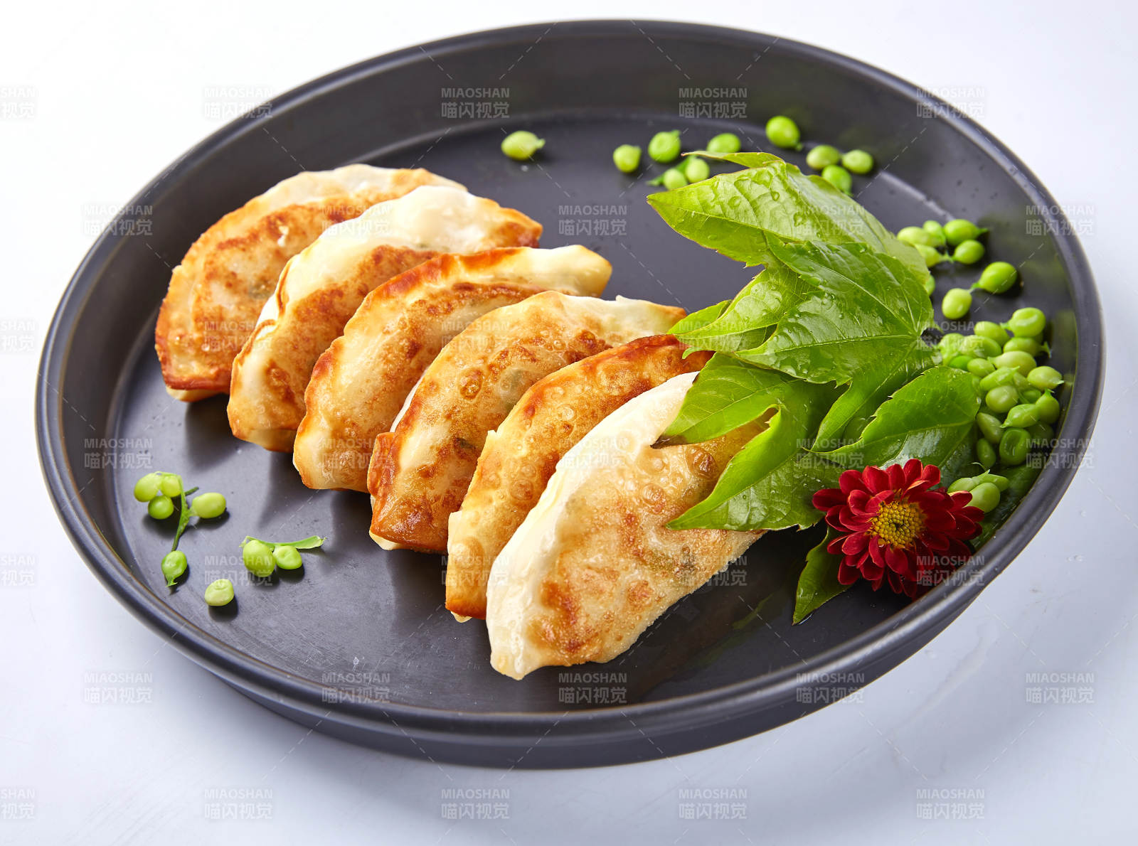 煎餃配豌豆與綠葉裝飾