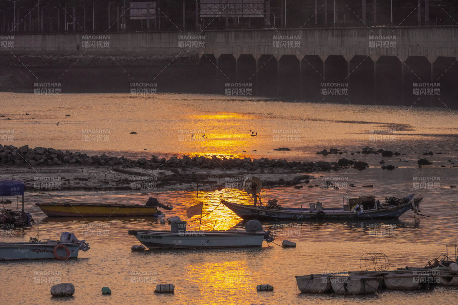 夕陽下的波光粼粼海面和漁船