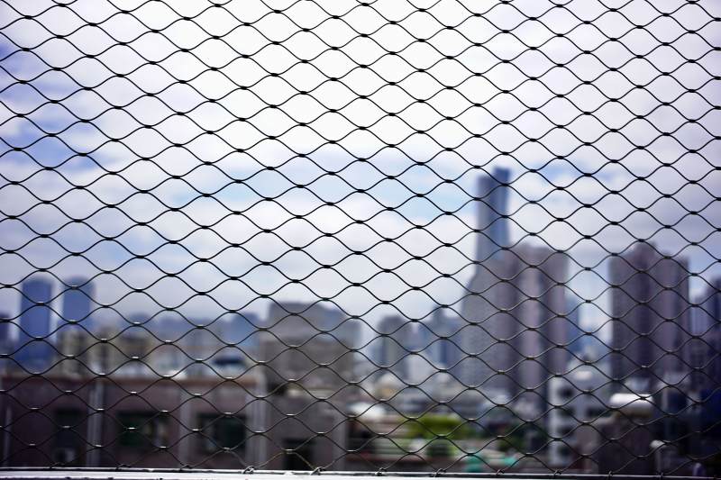 城市遠(yuǎn)景透過網(wǎng)狀圍欄
