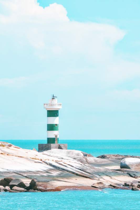 海邊綠白燈塔風景
