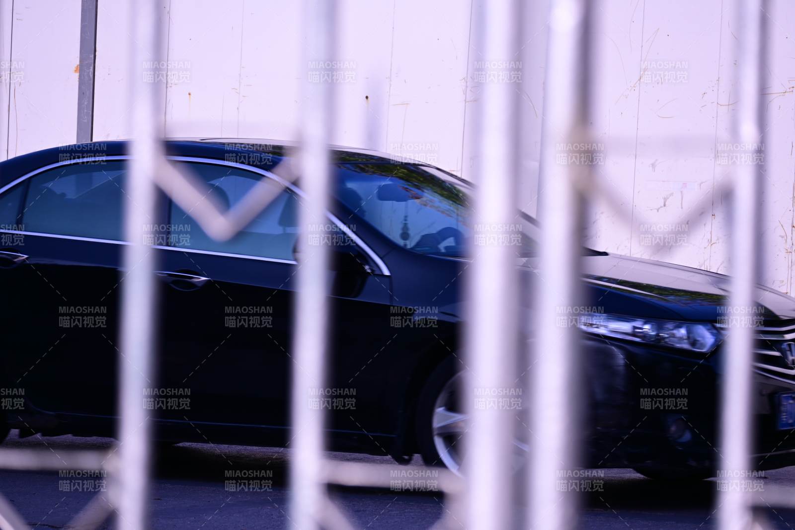 鐵柵欄后的黑色轎車