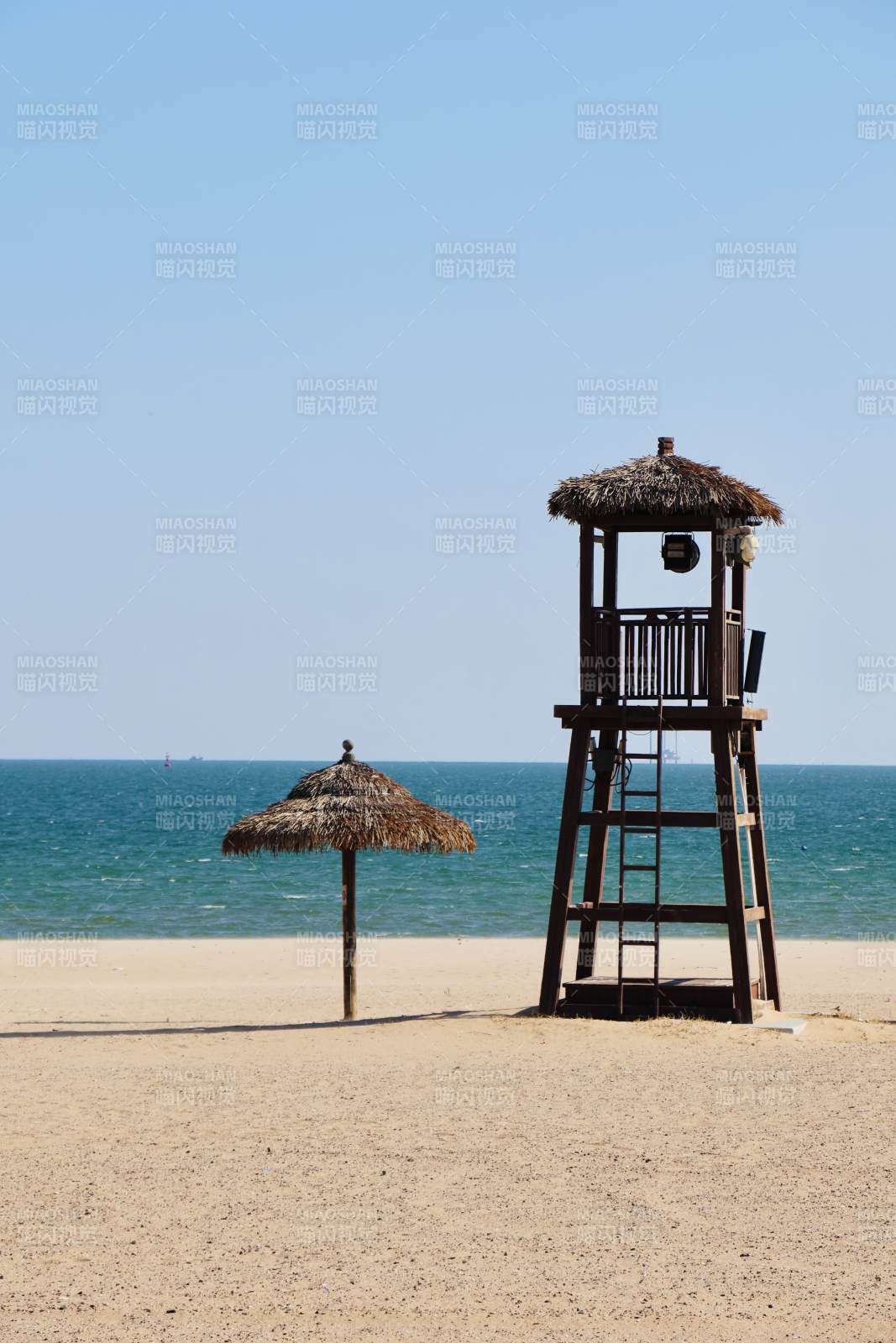 海灘上的瞭望塔和草傘