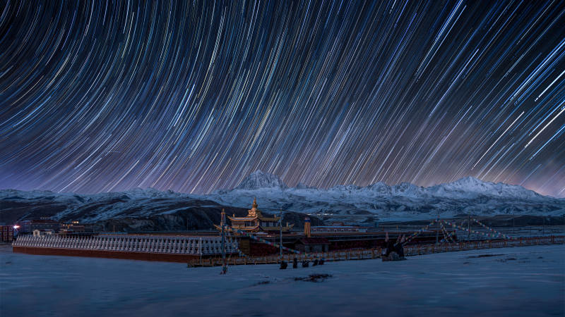 星轨下的雪山与建筑