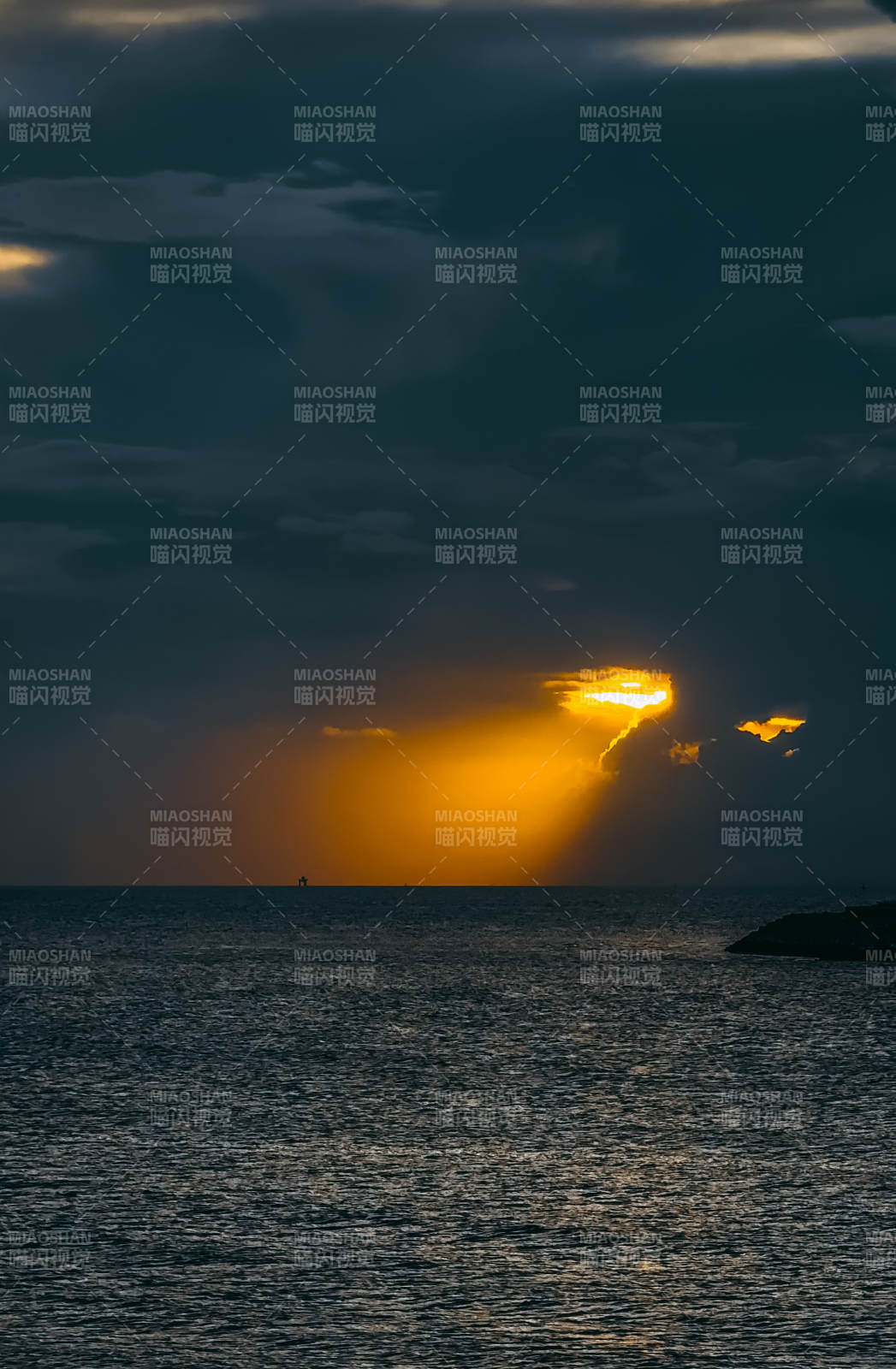 夕陽穿透云層照耀海面