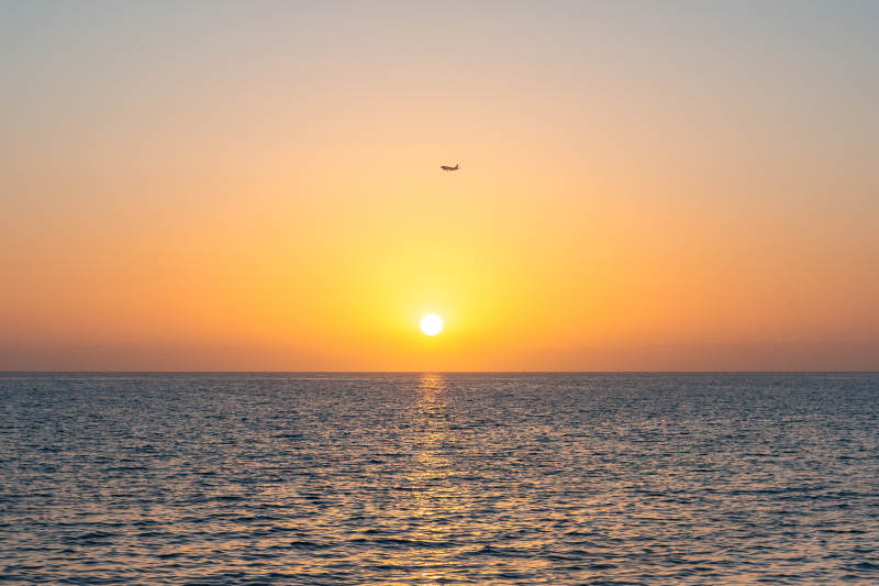 夕陽海面飛機掠影