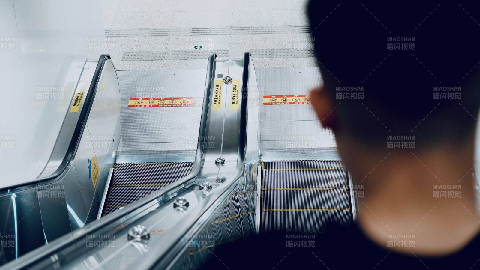 空曠的自動扶梯與背影