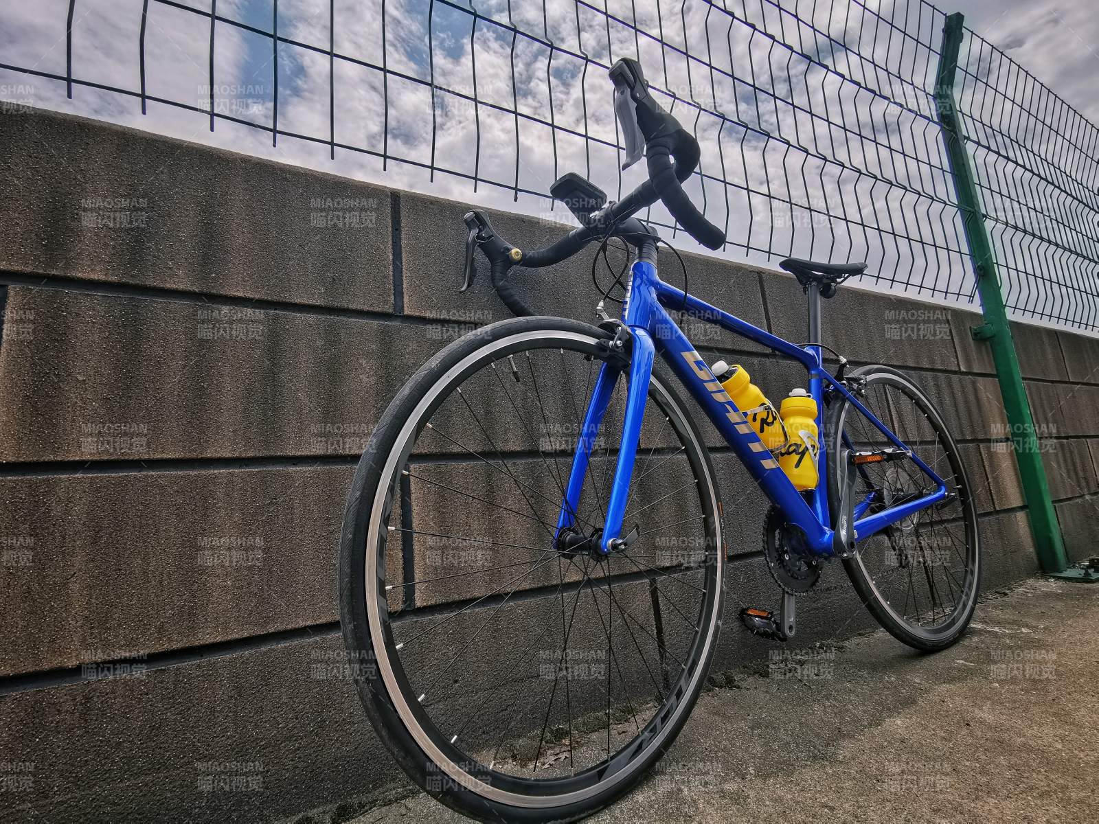 藍色自行車倚墻而立