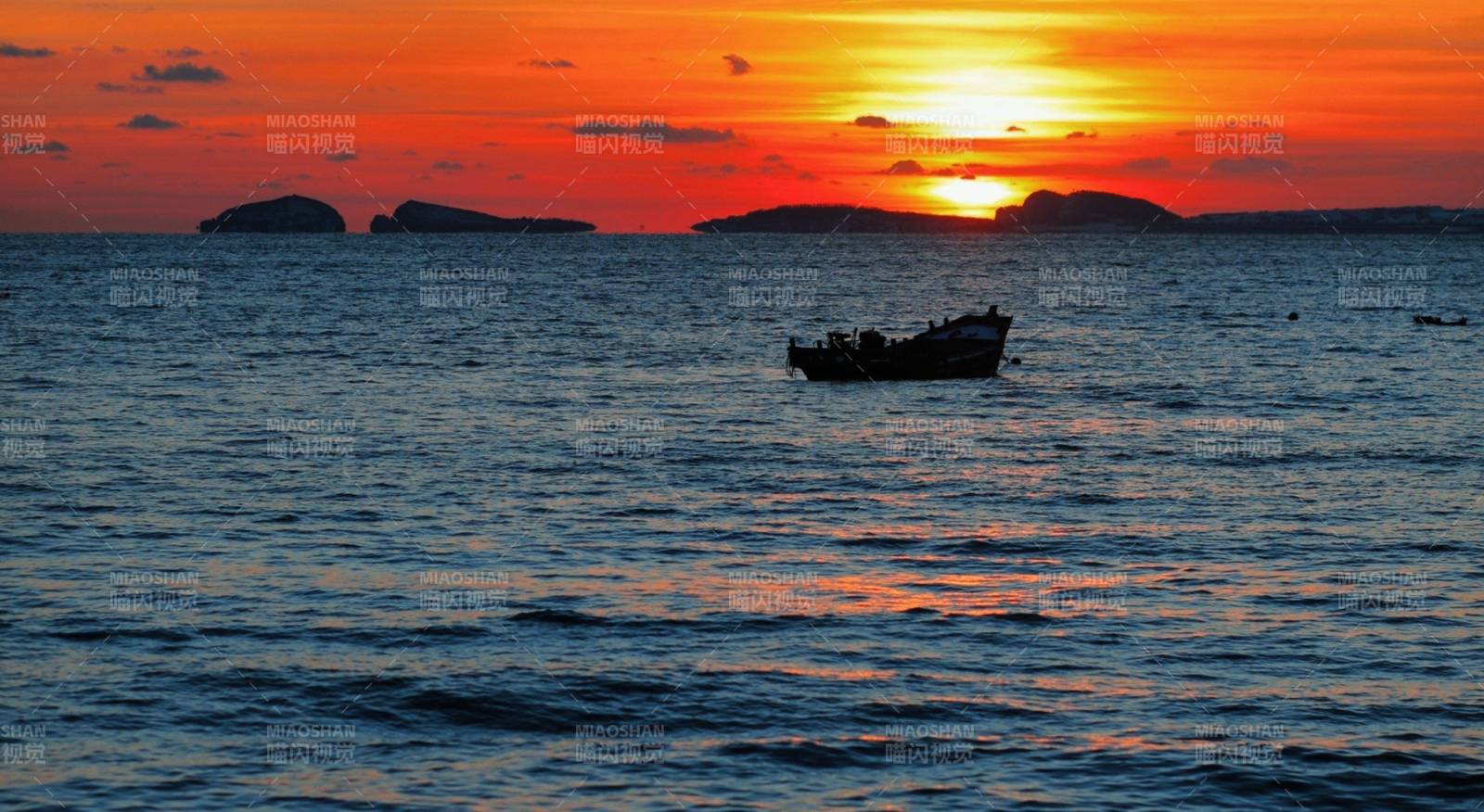 夕陽下的漁船與海島