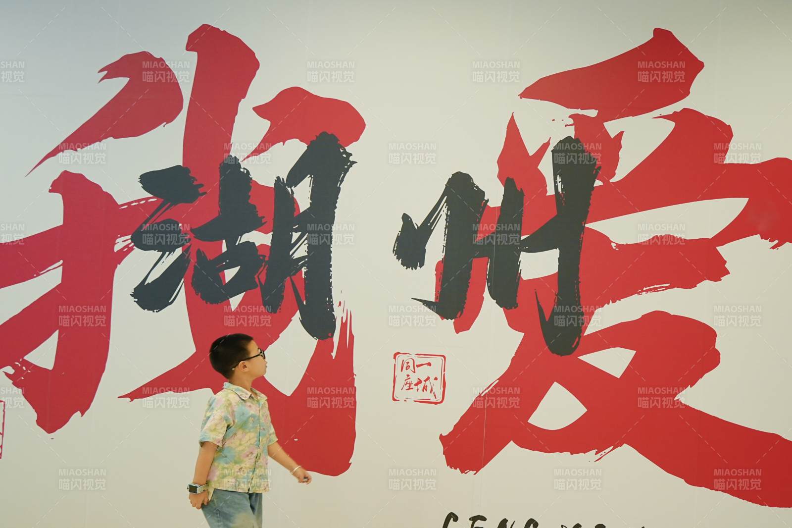 孩子走過(guò)書(shū)法墻前