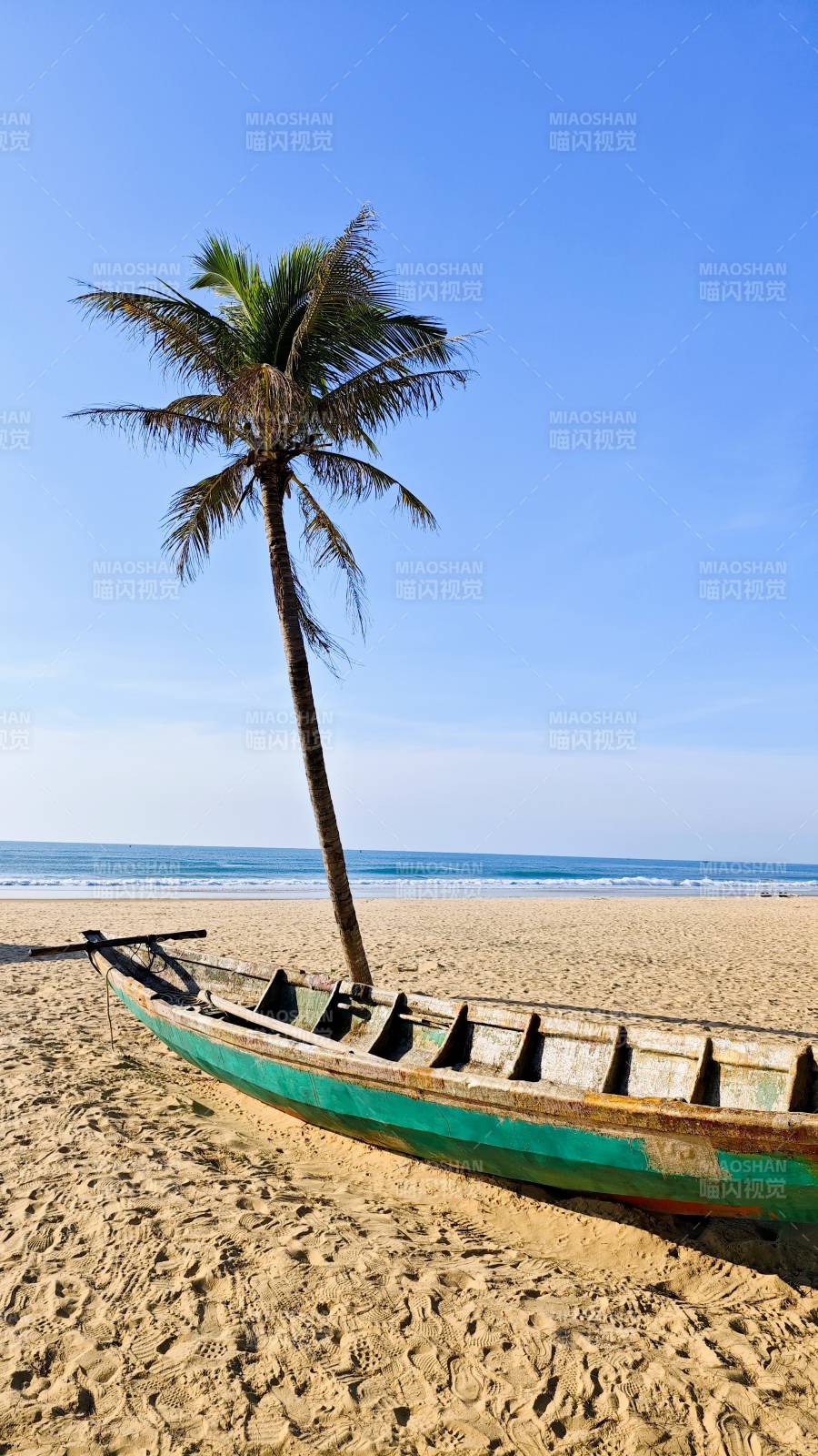 海南三亞南海沙灘上的椰樹與漁船