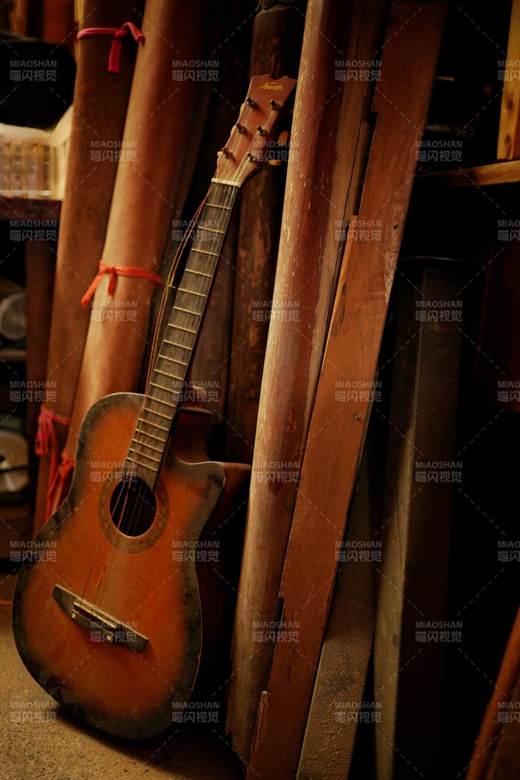 舊吉他倚木而立