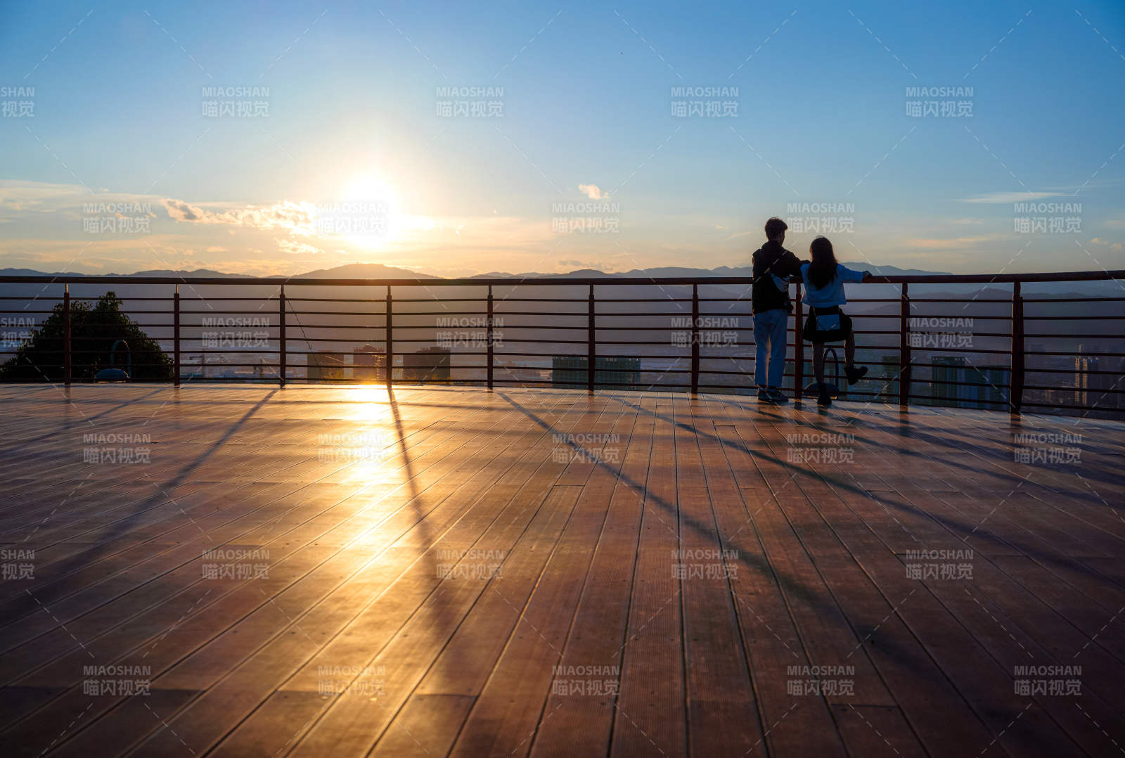 夕陽下觀景臺的戀人剪影