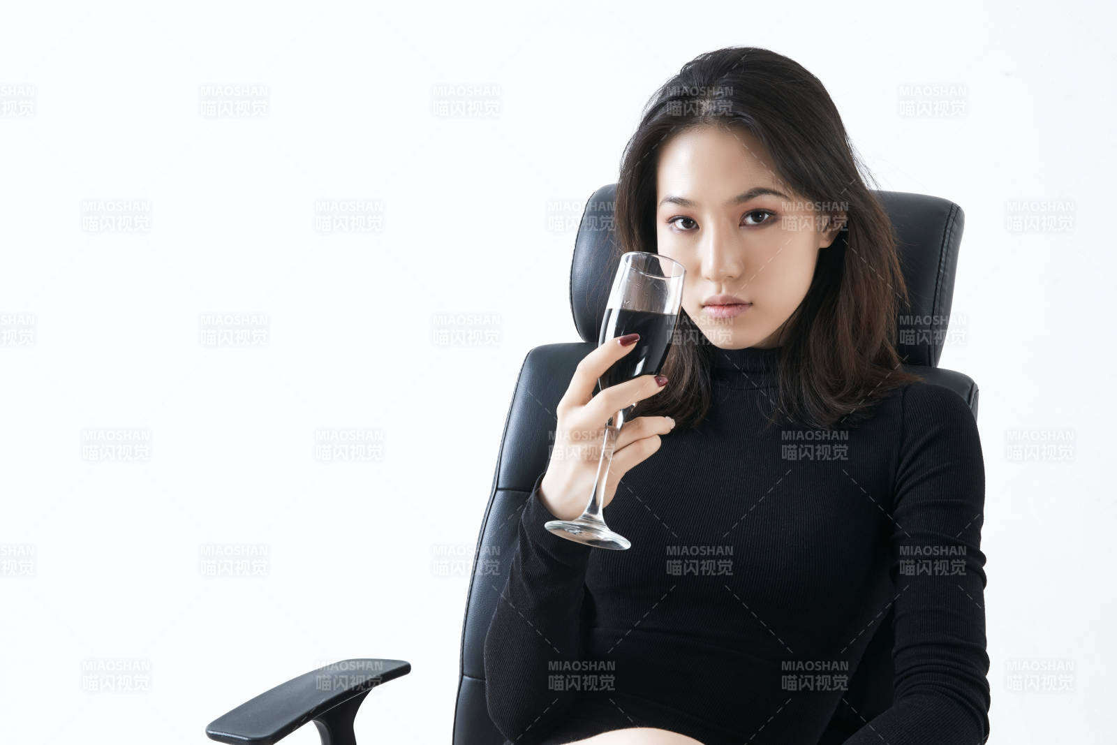 坐在椅子上獨自品嘗紅酒的亞洲女性