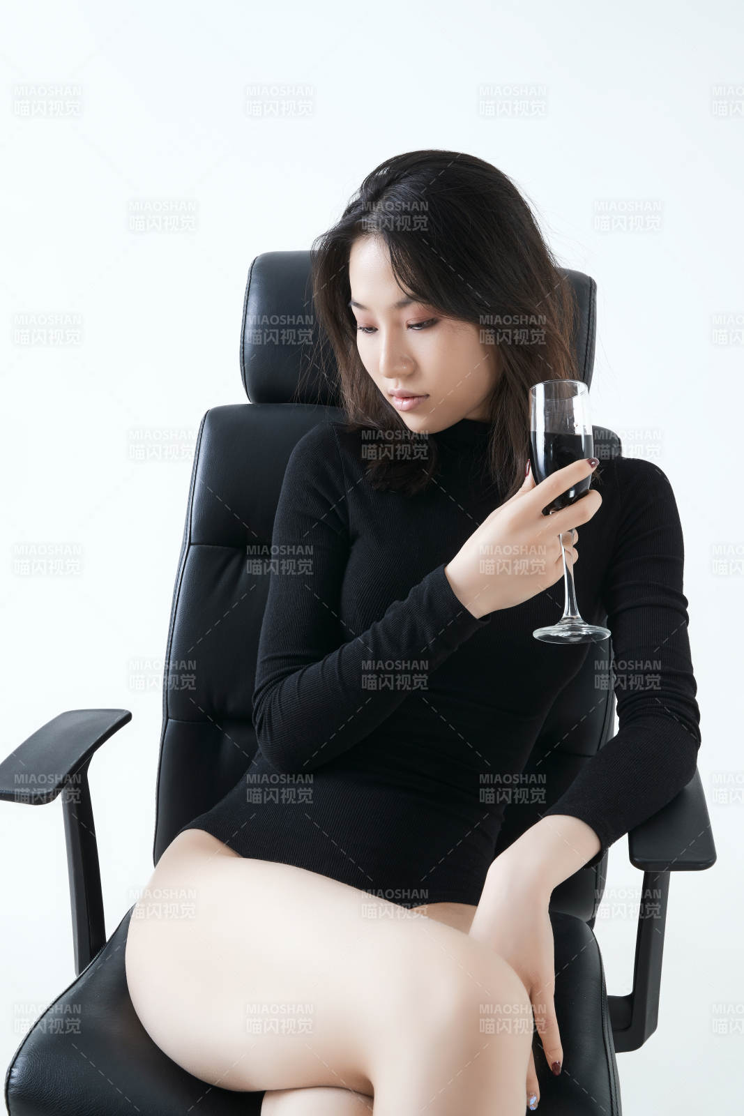 坐在椅子上獨(dú)自品嘗紅酒的亞洲女性