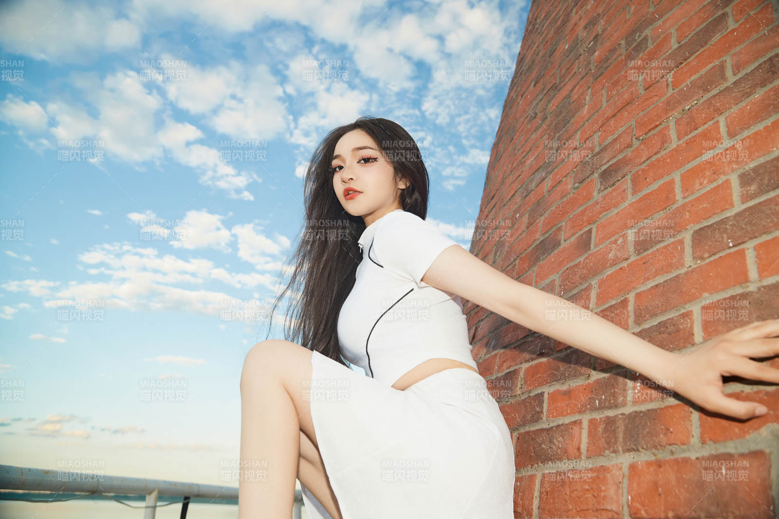 盛夏在景區湖邊燈塔上拍照游玩的美女