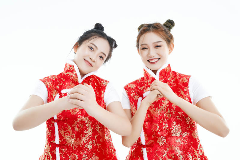 白色背景下身穿喜庆服饰的中国可爱少女