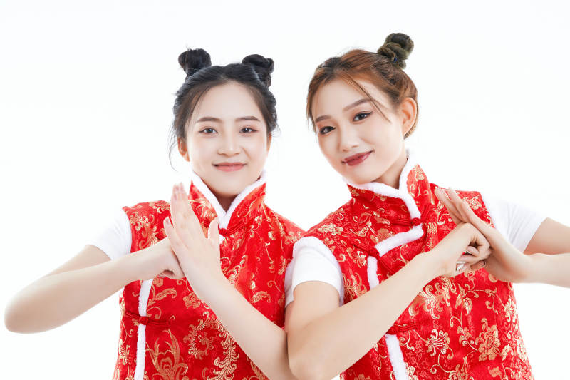 白色背景下身穿喜庆服饰的中国可爱少女