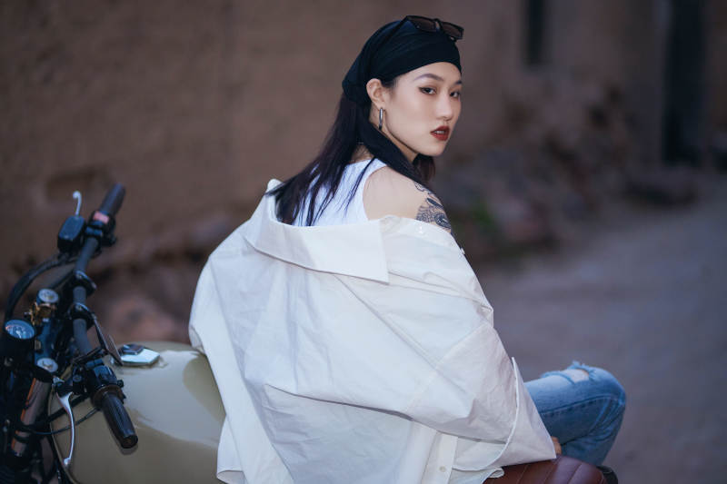 骑在复古摩托车上的时尚亚洲少女