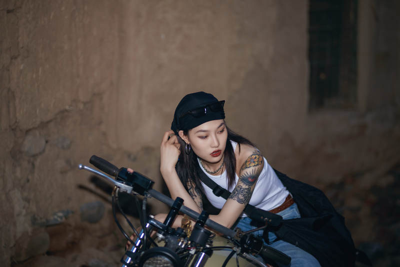 骑在复古摩托车上的时尚亚洲少女