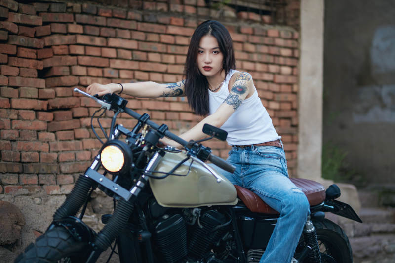 骑在复古摩托车上的时尚亚洲少女