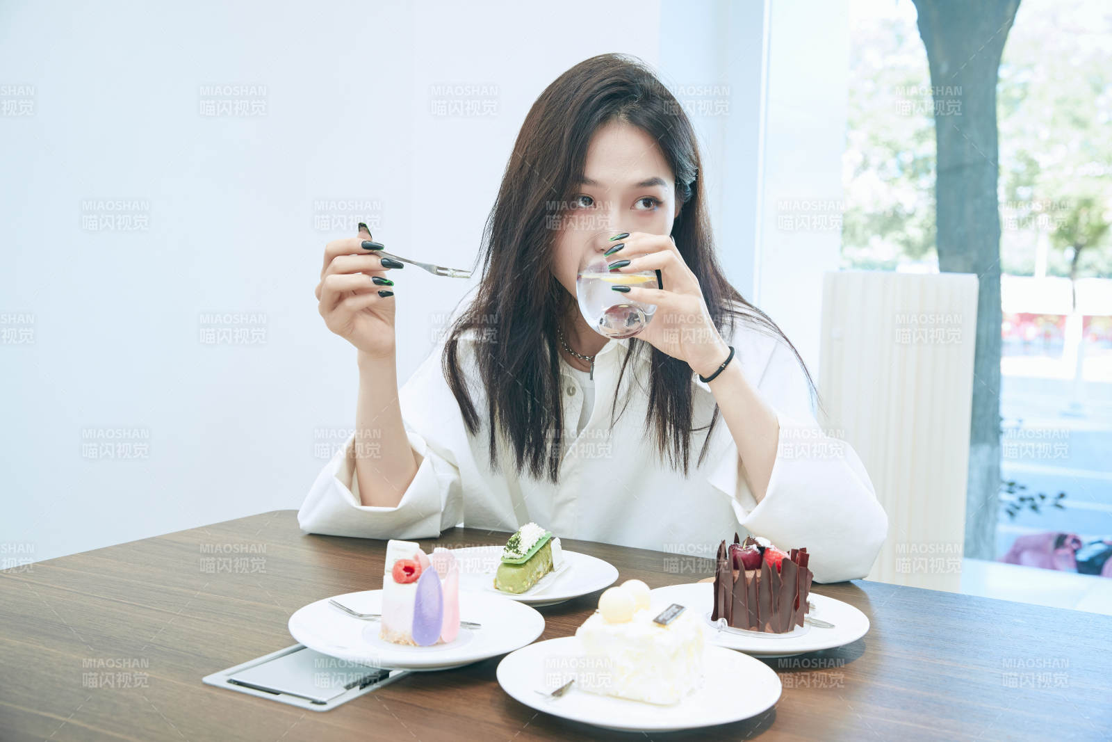 在烘焙店吃蛋糕喝飲料的可愛亞洲少女