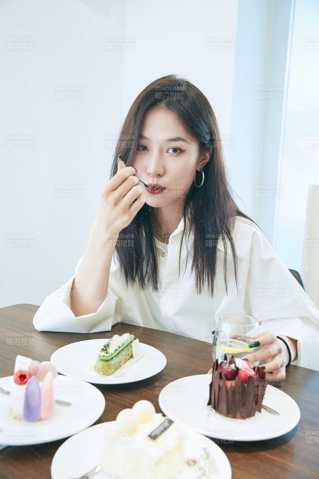 在烘焙店吃蛋糕喝飲料的可愛(ài)亞洲少女