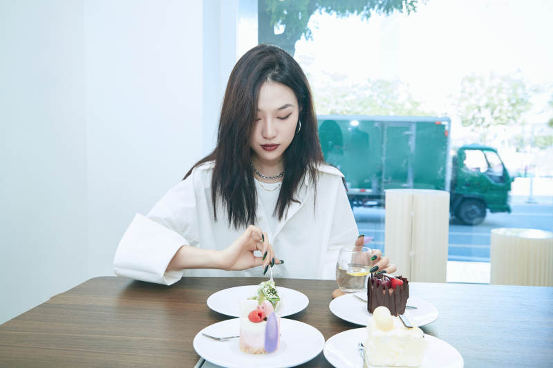 在烘焙店吃蛋糕喝饮料的可爱亚洲少女图片