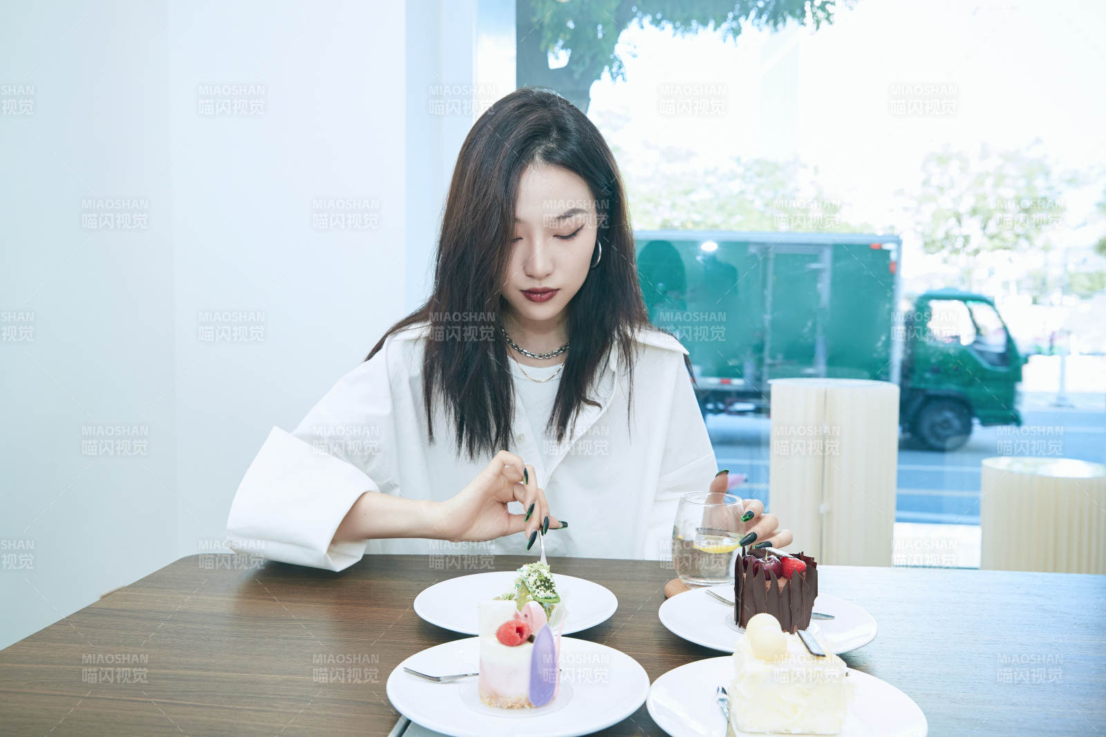 在烘焙店吃蛋糕喝饮料的可爱亚洲少女图片