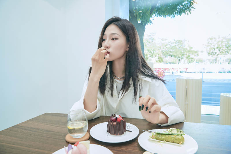 在烘焙店吃蛋糕喝饮料的可爱亚洲少女图片