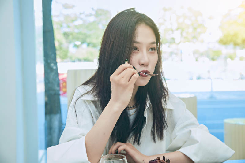 在烘焙店吃蛋糕喝饮料的可爱亚洲少女图片