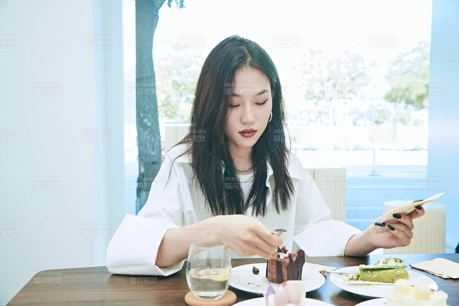 在烘焙店吃蛋糕喝饮料的可爱亚洲少女图片