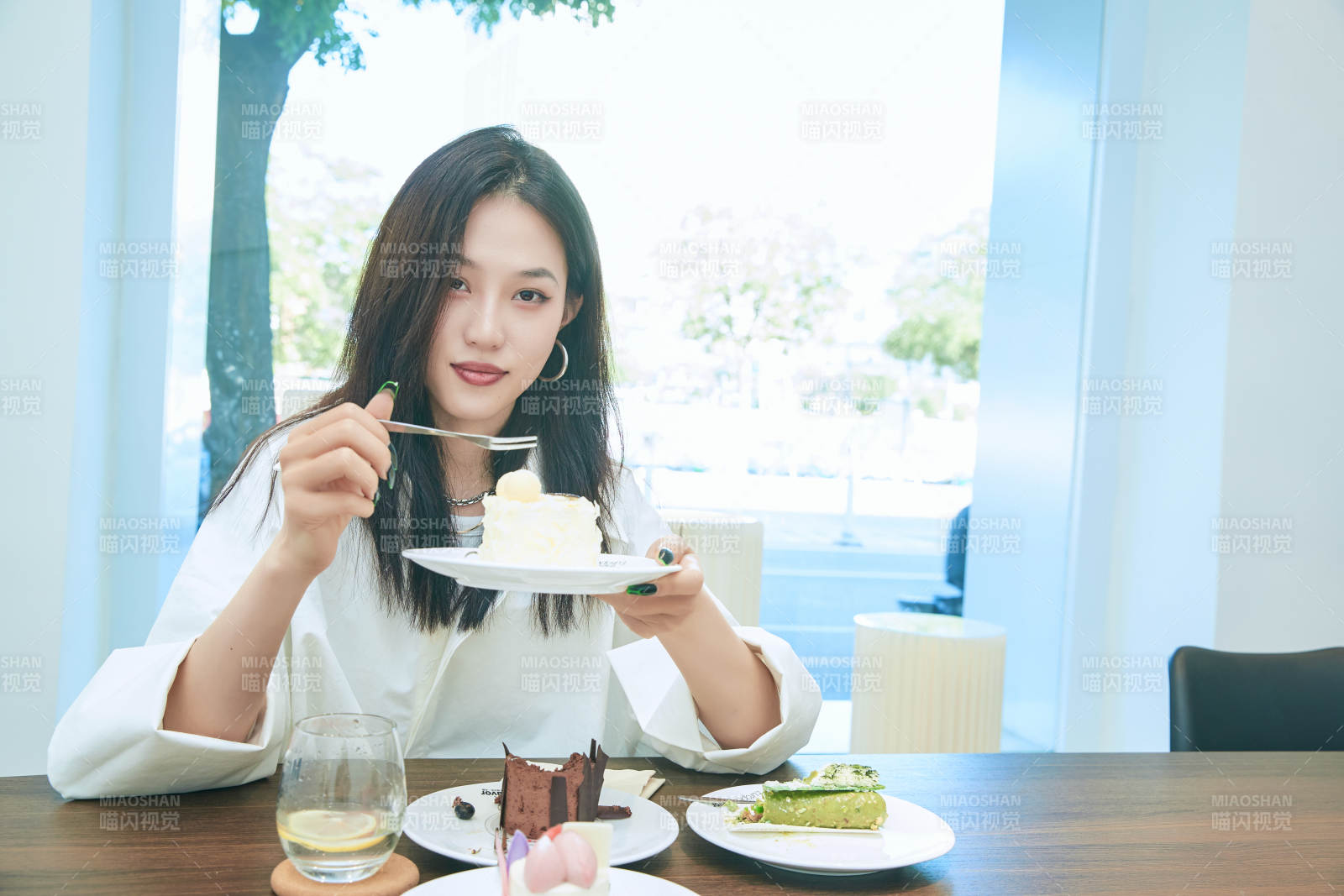 在烘焙店吃蛋糕喝飲料的可愛(ài)亞洲少女