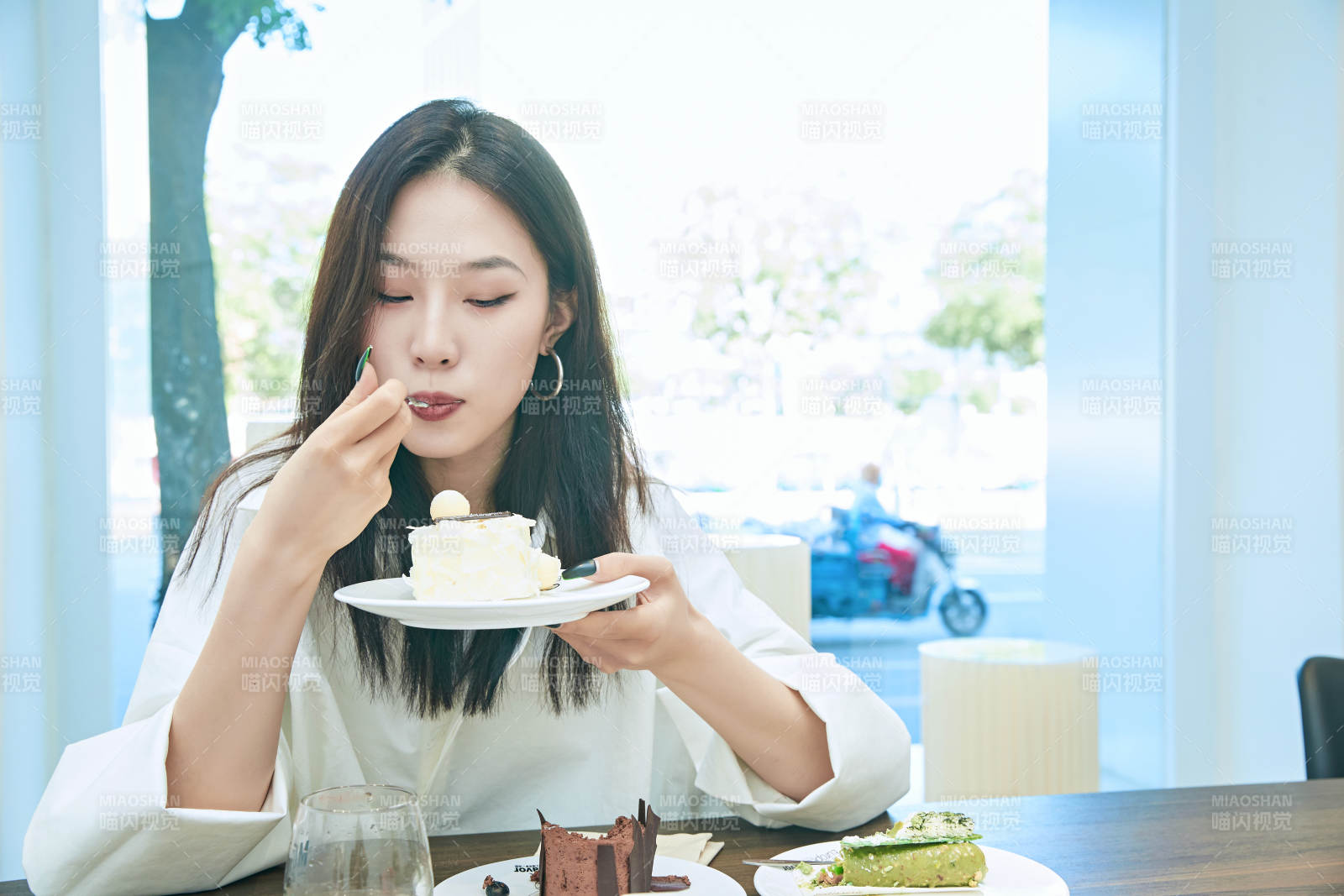 在烘焙店吃蛋糕喝飲料的可愛亞洲少女