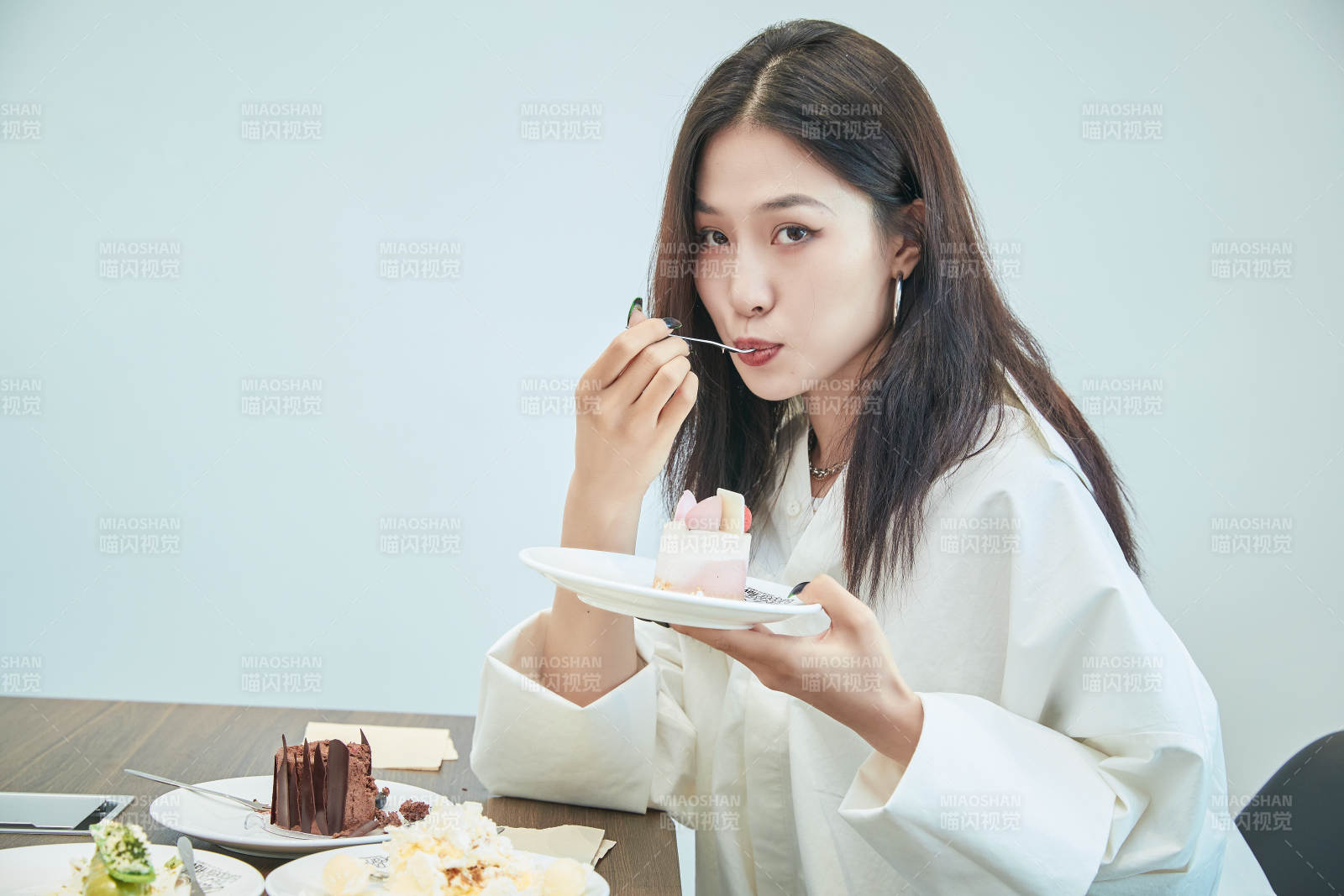 在烘焙店吃蛋糕喝飲料的可愛(ài)亞洲少女