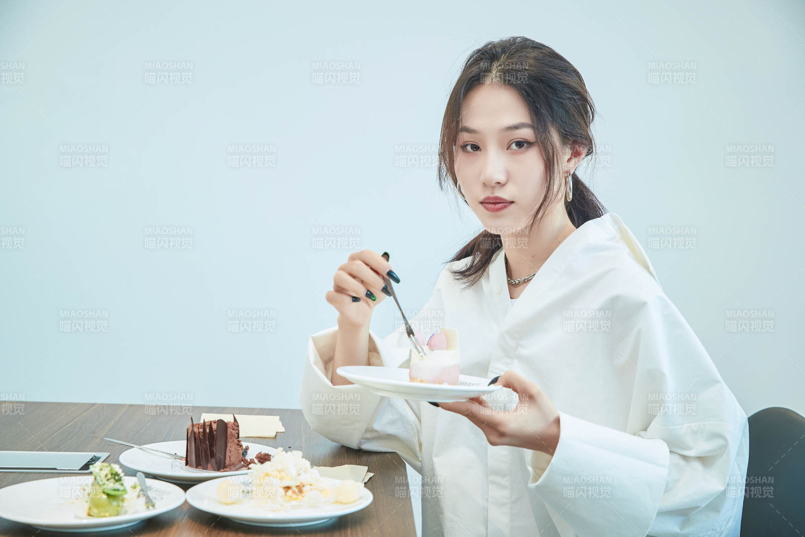 在烘焙店吃蛋糕喝飲料的可愛(ài)亞洲少女