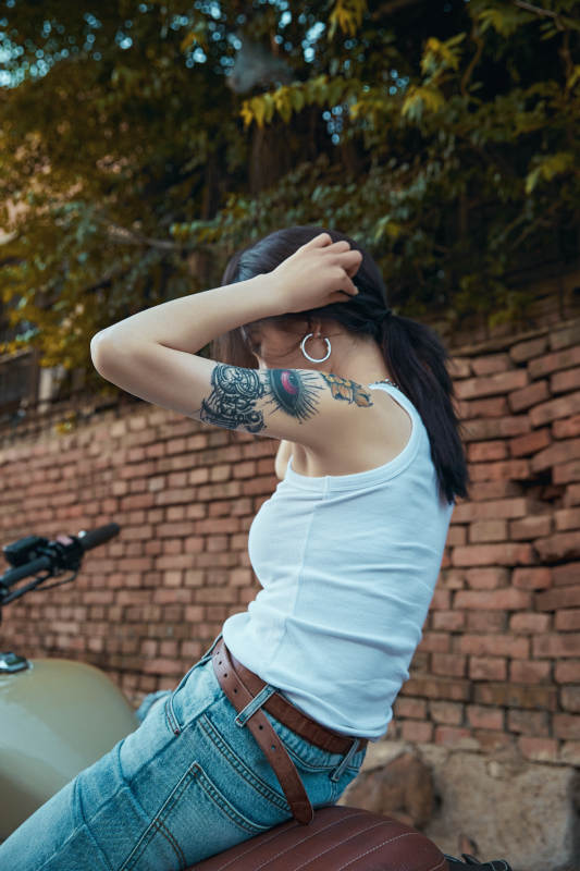 骑在复古摩托车上的时尚亚洲少女