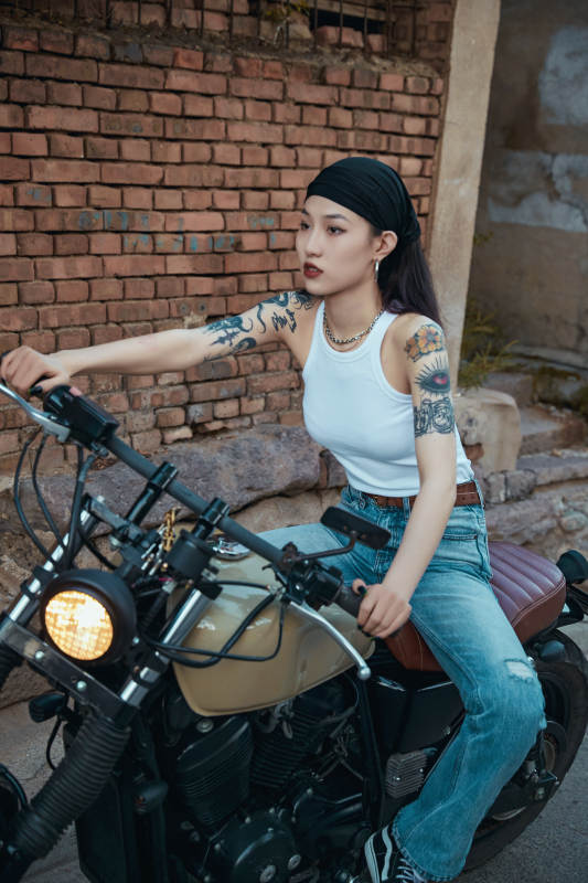 骑在复古摩托车上的时尚亚洲少女