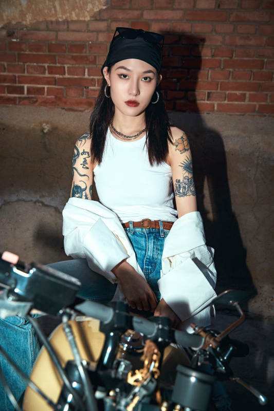 骑在复古摩托车上的时尚亚洲少女