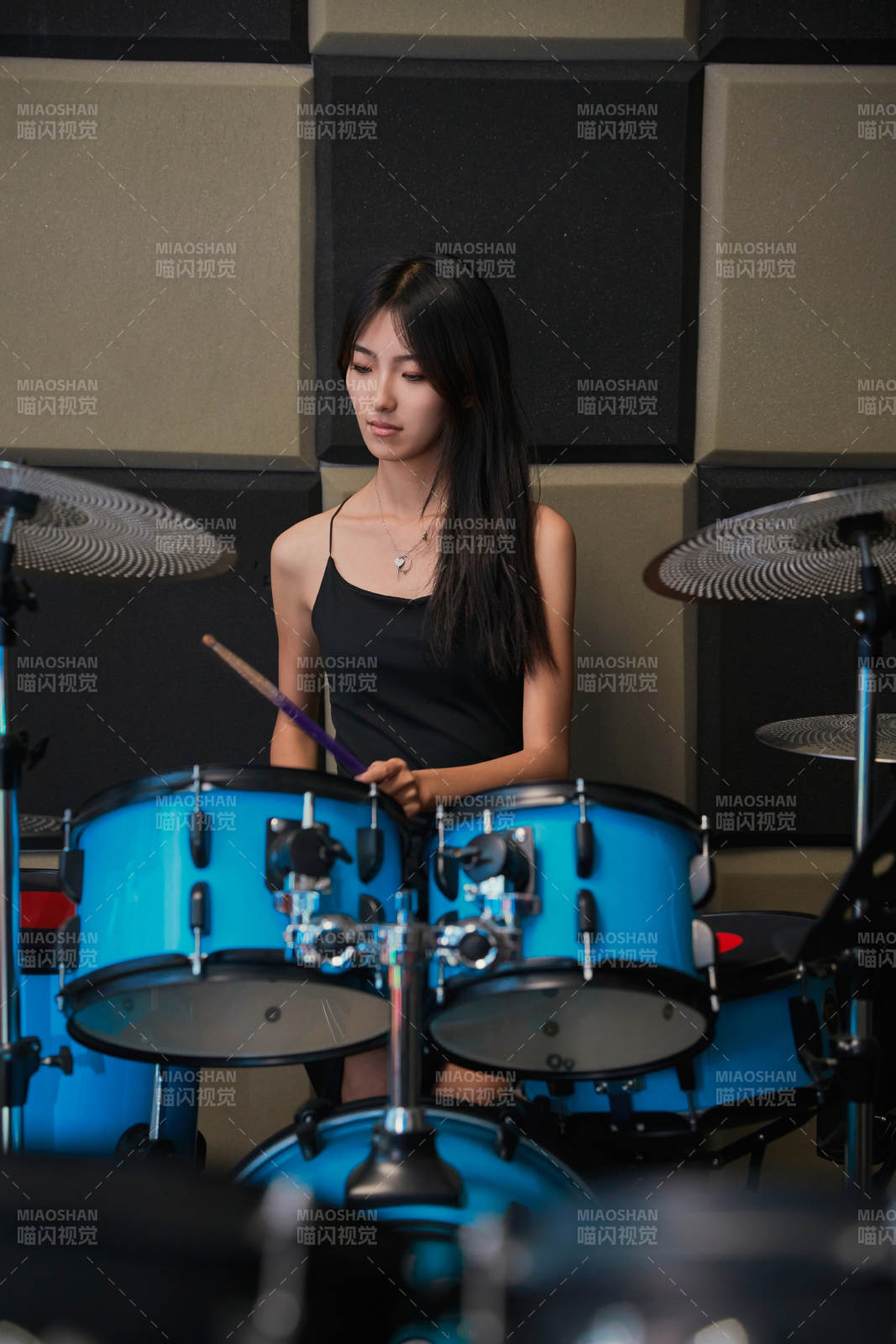 在排練室打爵士鼓的亞洲少女