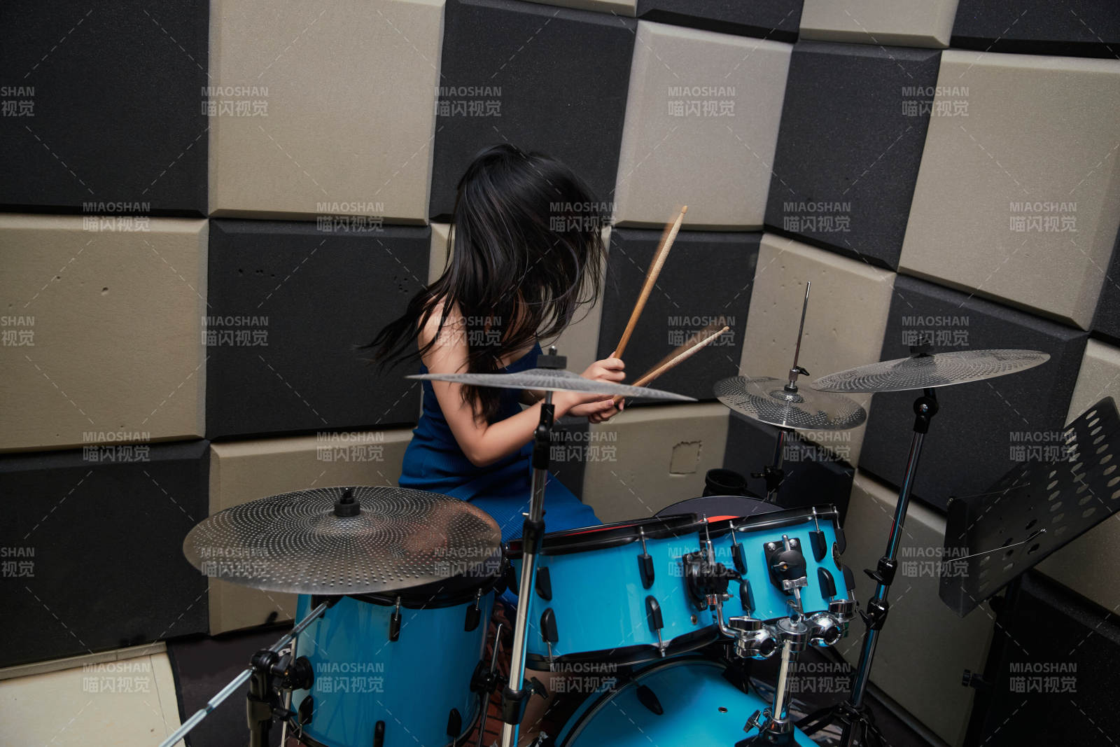 在排練室打爵士鼓的亞洲少女