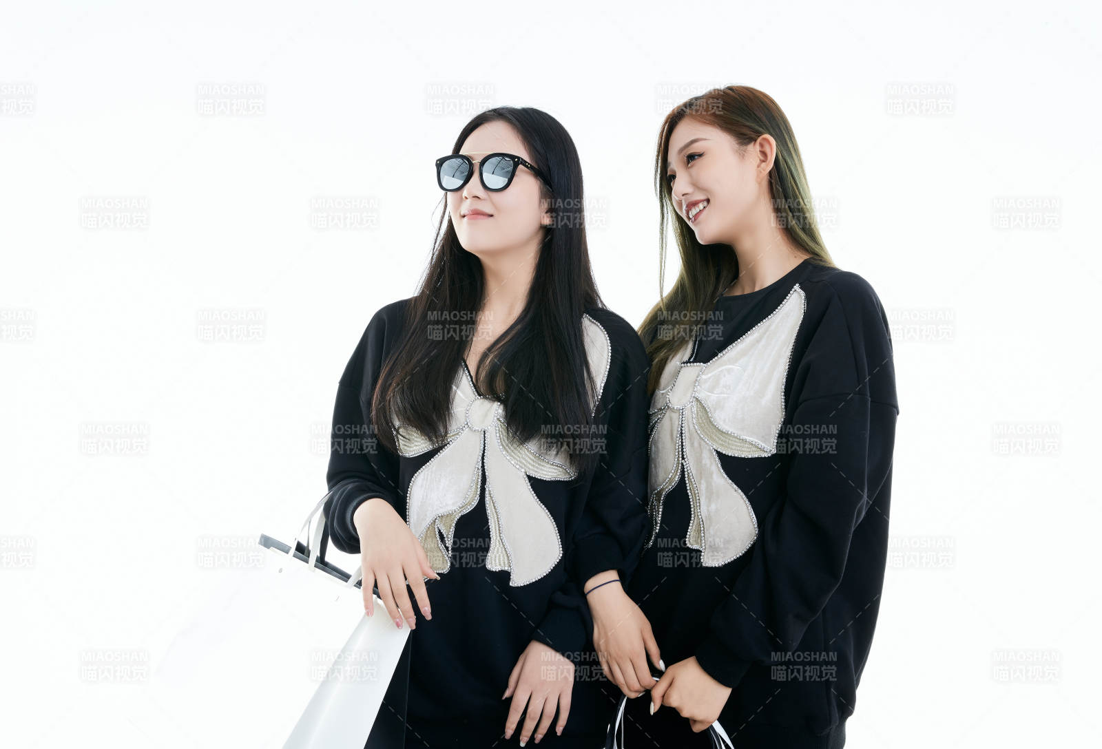 白色背景下手提購物袋時尚美麗的閨蜜