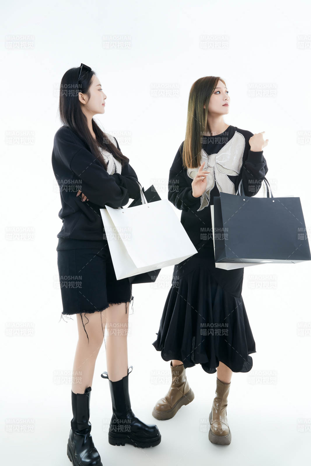 白色背景下手提購(gòu)物袋時(shí)尚美麗的閨蜜