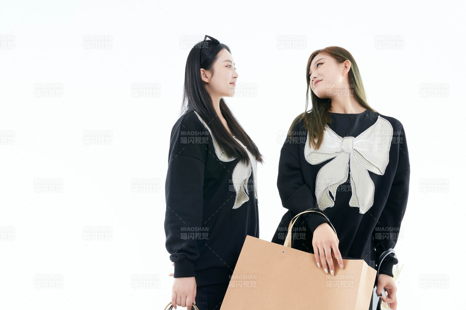 白色背景下手提購物袋時尚美麗的閨蜜