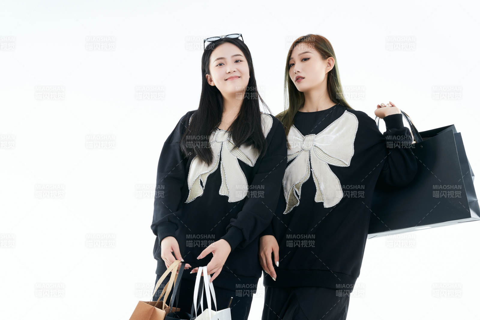 白色背景下手提購(gòu)物袋時(shí)尚美麗的閨蜜