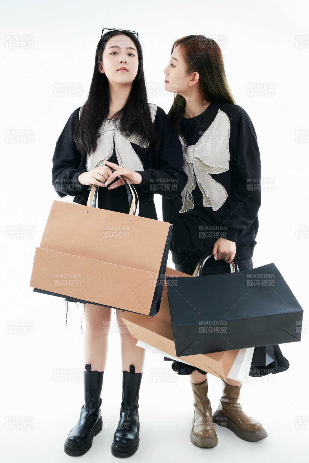 白色背景下手提購物袋時(shí)尚美麗的閨蜜